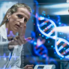 Naukowczyni analizuje na ekranie spiralę DNA, dyskutując z koleżanką, czy to geny czy wychowanie kształtują człowieka.