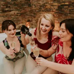 Trzy przyjaciółki świętują w jacuzzi, kiedy robi się panienski. Nalewają szampana do kieliszków, otoczone ciepłym blaskiem świec.