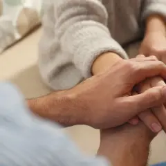Dłonie splatają się, oferując wsparcie i słowa pocieszenia w trudnych chwilach. Bliskość i zrozumienie.