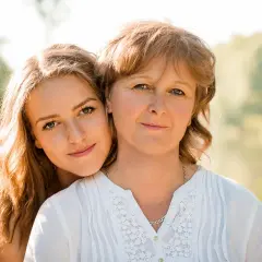 Uśmiechnięta córka przytula się do mamy. Choć czasem córka obwinia mnie o wszystko, w tym momencie czuć miłość.