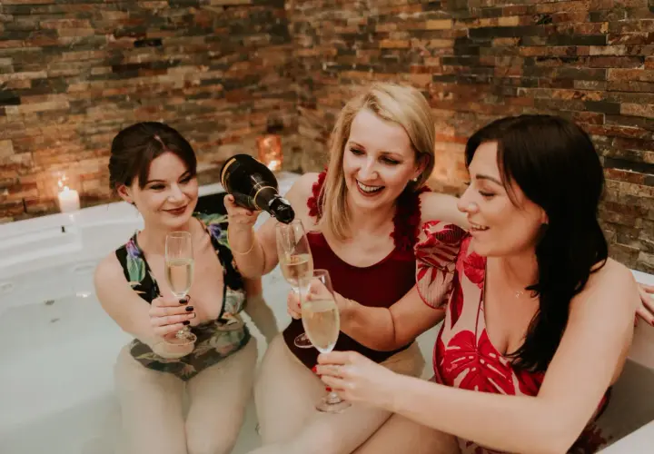Trzy przyjaciółki świętują w jacuzzi, kiedy robi się panienski. Nalewają szampana do kieliszków, otoczone ciepłym blaskiem świec.