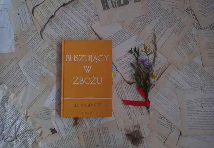 Buszujący w zbożu J.D. Salingera, opowieść o dojrzewaniu i poszukiwaniu autentyczności, leży na pożółkłych kartkach.