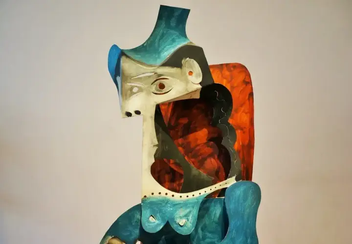 Abstrakcyjna rzeźba w stylu pablo picasso, z geometrycznymi kształtami i żywymi kolorami, przedstawiająca postać kobiecą.