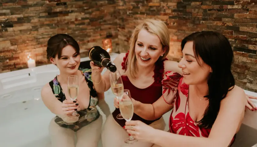Trzy przyjaciółki świętują w jacuzzi, kiedy robi się panienski. Nalewają szampana do kieliszków, otoczone ciepłym blaskiem świec.