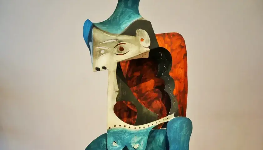 Abstrakcyjna rzeźba w stylu pablo picasso, z geometrycznymi kształtami i żywymi kolorami, przedstawiająca postać kobiecą.