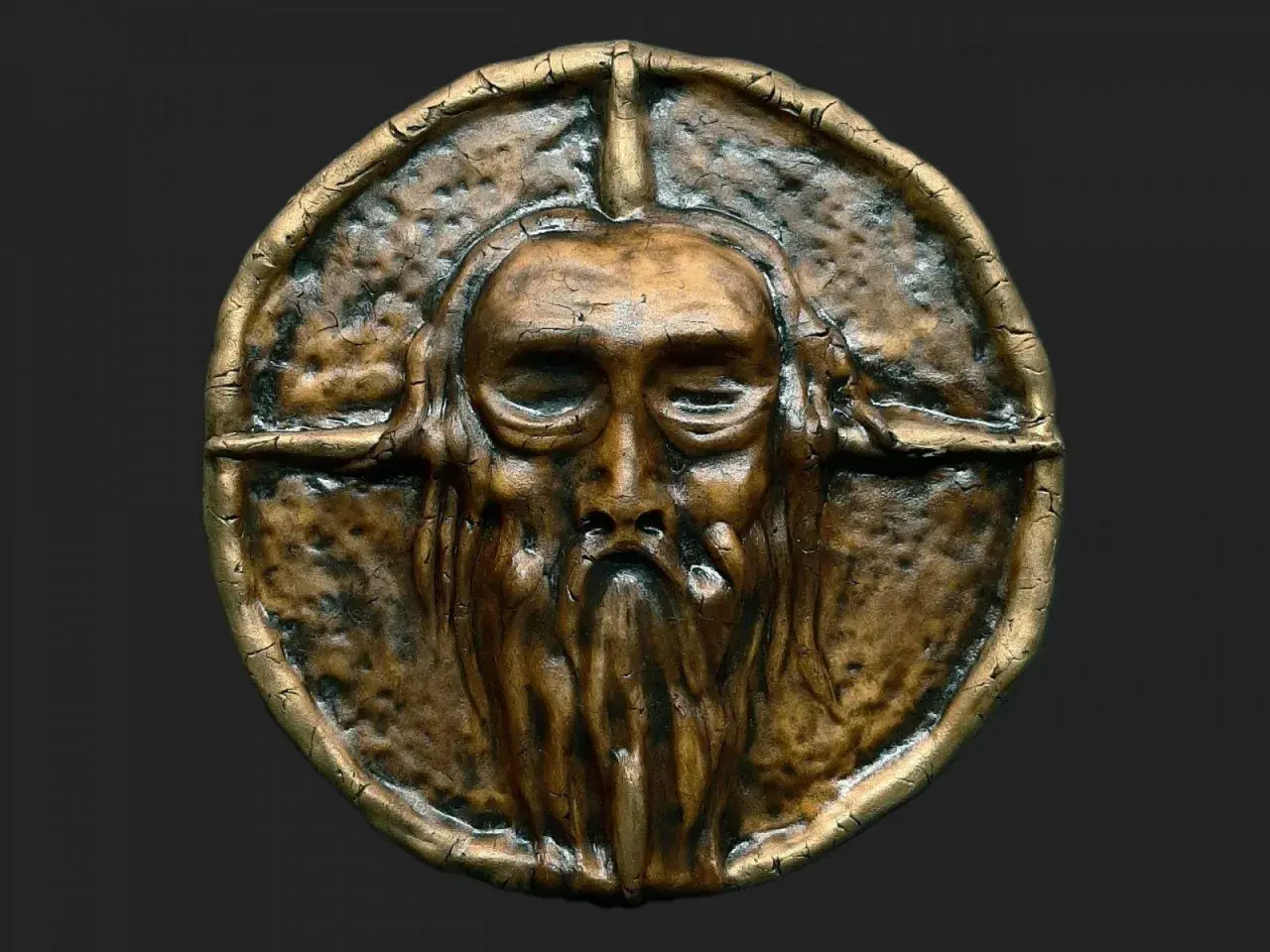 Starożytna, mosiężna maska z brodatą twarzą. Symbolizuje siłę i mądrość, przypominając, co to ród.