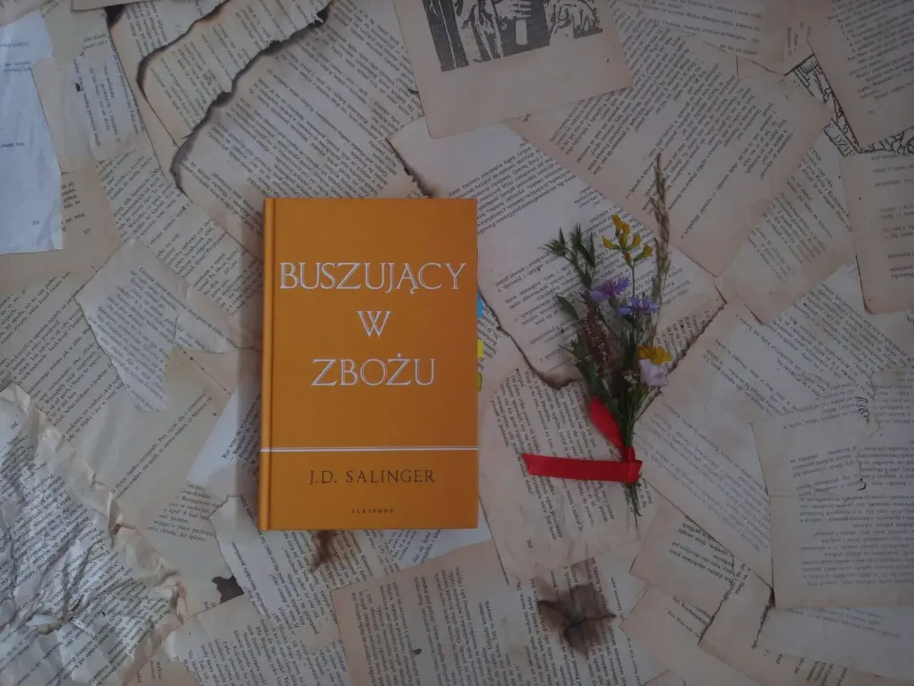 Buszujący w zbożu J.D. Salingera, opowieść o dojrzewaniu i poszukiwaniu autentyczności, leży na pożółkłych kartkach.