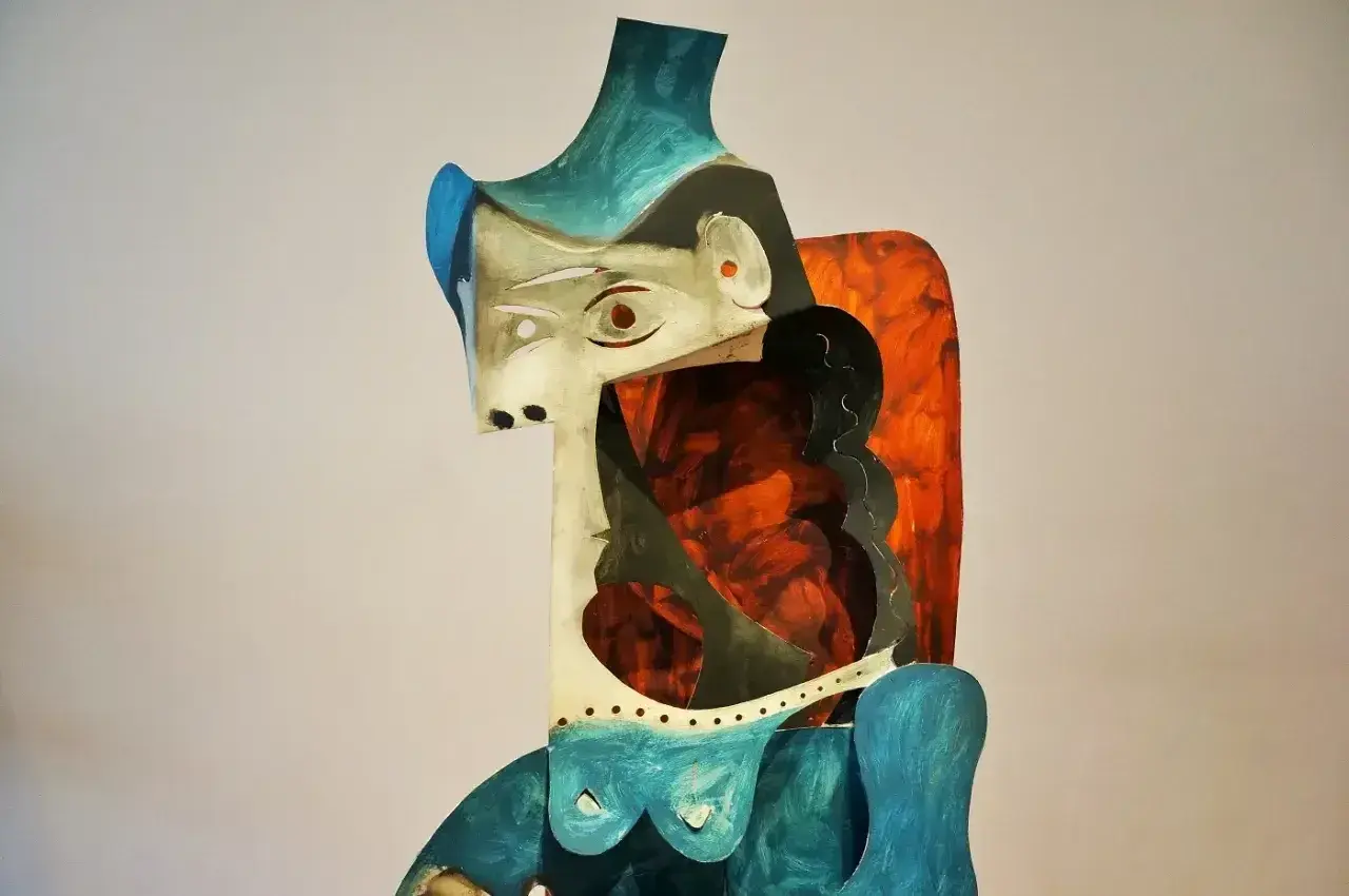 Abstrakcyjna rzeźba w stylu pablo picasso, z geometrycznymi kształtami i żywymi kolorami, przedstawiająca postać kobiecą.