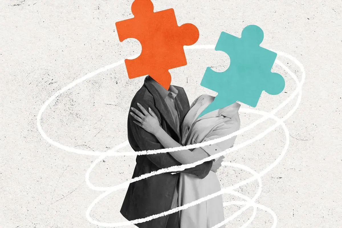 Dwie postacie przytulają się, ich głowy zastąpione są przez puzzle. Moja dorosła córka nie akceptuje mojego partnera, co symbolizuje ten obraz.