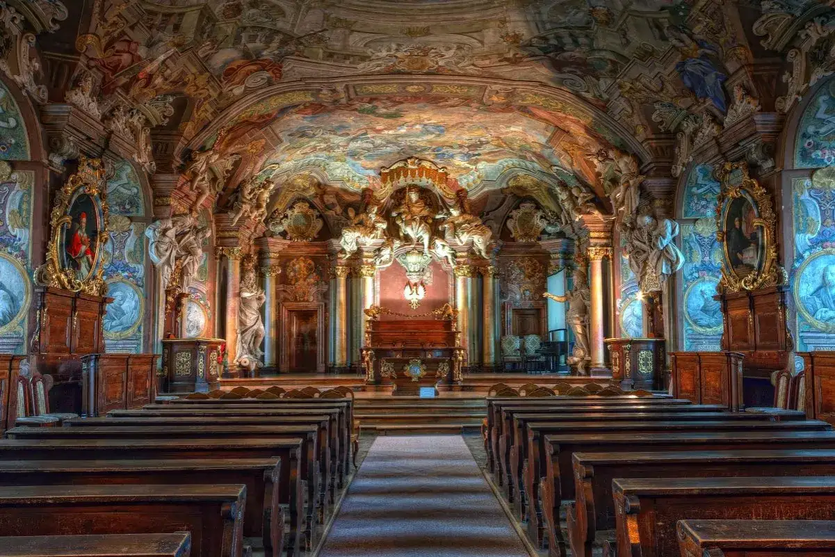 Wnętrze biblioteki z bogatymi zdobieniami, malowidłami na sklepieniu i rzeźbami. To arcydzieło barok w Polsce, pełne przepychu i historii.