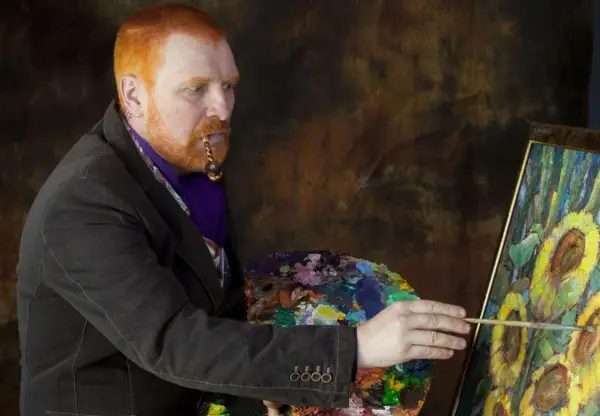 Mężczyzna z rudą brodą i fajką w ustach, malujący słoneczniki. Ciekawe van gogh ciekawostki o jego życiu i sztuce.