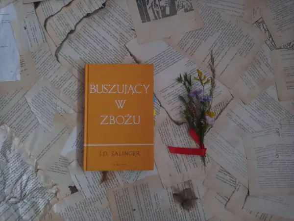 Buszujący w zbożu J.D. Salingera, opowieść o dojrzewaniu i poszukiwaniu autentyczności, leży na pożółkłych kartkach.